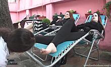 Dua gadis bersantai di recliners dan kaki mereka dijilat