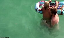 Seorang wanita berambut pirang menikmati seks di bawah air dengan pacarnya