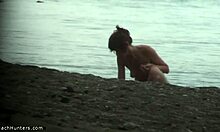 Худощавая женщина демонстрирует свое полностью обнаженное тело на нудистском пляже