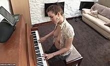 Brune à l'air joueuse avec des seins fermes jouant du piano topless