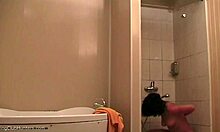 Ohromujúca žena relaxuje pod sprchou a je sledovaná