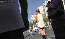 Una bella ragazza dalle gambe lunghe in bianco mostra le sue gambe snelle alla fermata dell'autobus