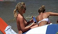 Prietenele blonde își arată sânii și trupurile fierbinți pe o plajă