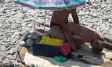 탠라인에서 뒤에서 받는 섹시한 여자가 바위가 있는 해변에서 섹스를 합니다