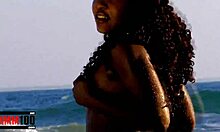 Sulten sort kvinde nyder at klæde sig af i havet