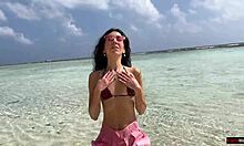 Kultainen suihku rannalla Malediiveilla kauniille tytölle, joka pissaa